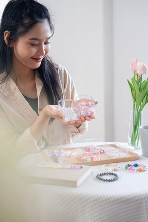 Young girl making handmade bracelets with fun and cheerfulness