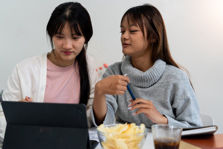 Female higher education students using laptop and studying in home, Online learning.の写真素材