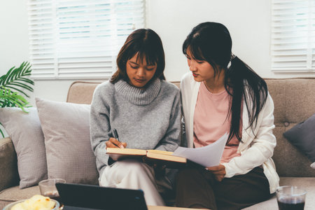 Female higher education student studying book in home, Online learning.の写真素材