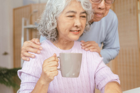 senior couple with laptop and documents on sofa. Elderly man, woman with smile, computer or...
