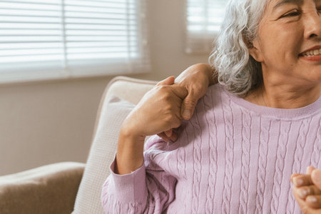 Happy couple spending quality time together in cozy modern home. They are having a conversation, drinking coffee while the wife sitting on a sofa and husband on chair in the living room, displaying love, affection, togetherness.の写真素材
