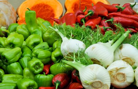 A colorful closeup of vegetables - fennel (anise), green peppers, red peppers and squash at a farmers marketの写真素材