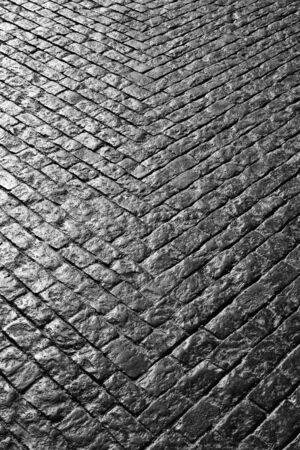 Grey cobbled street with bricks making a V shapeの写真素材