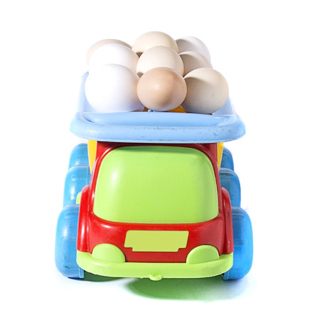 chicken eggs on toy car on white background with blank card. Abstract retro concept.の写真素材