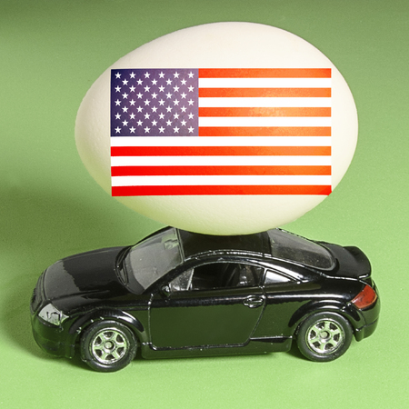 chicken eggs on toy car on green background with blank card. Abstract retro concept.の写真素材