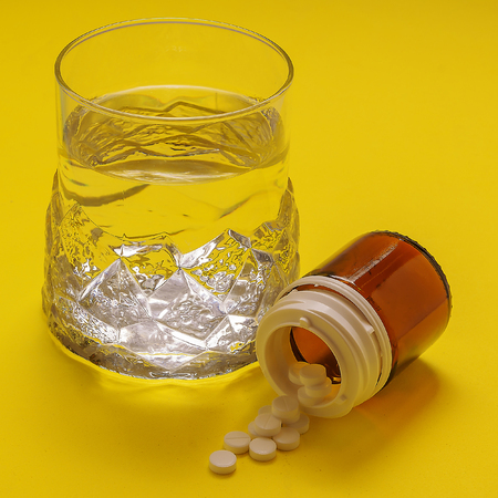 high resolution photo on yellow background, disease treatment on which Tablet glass of water, for medicine, health, pharmacy, recipes,の写真素材
