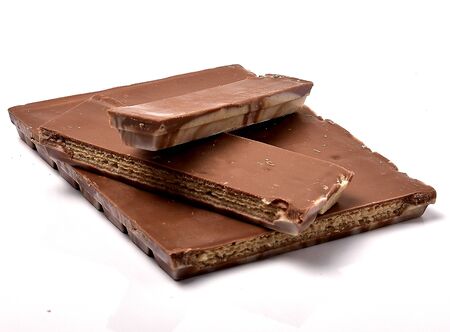 Pieces of delicious chocolate on a white background, intended for consumptionの写真素材