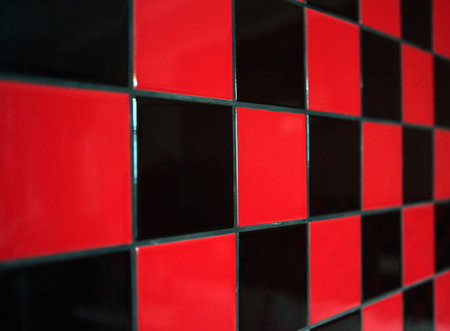 Wall with a red and black tile. The limited sharpness
