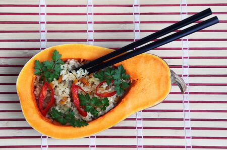 Rice with the vegetables, served in a pumpkin with chopsticksの写真素材