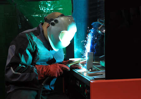 Welder uses torch to make sparks during manufacture of metal equipment.の写真素材