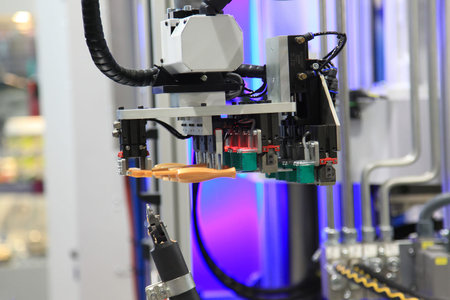 Industrial robot moves ready screwdriver in the machine