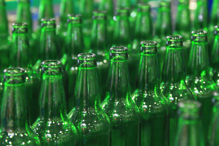 Many bottles on conveyor belt in factory production of beverages
