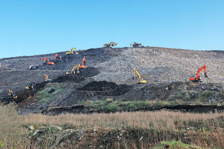Reclamation of solid waste landfill by heavy machinery
