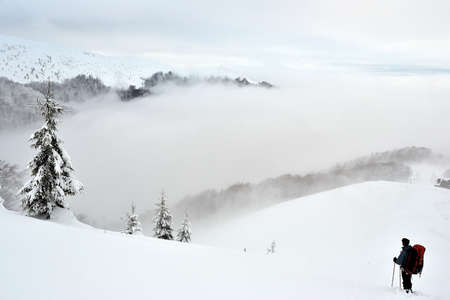 A tourist in winter in the mountains of Carpathiansの写真素材