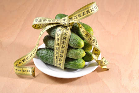 Cucumbers with yellow measuring tapeの写真素材