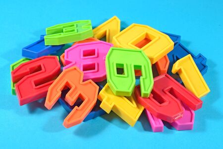 Heap of plastic colored numbers on a blue background close upの写真素材