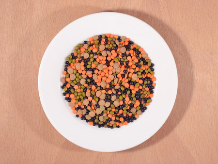 Mixture of dried lentils and beans on a white plateの写真素材