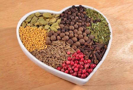 Different dry spices in plate in the form of heartの写真素材