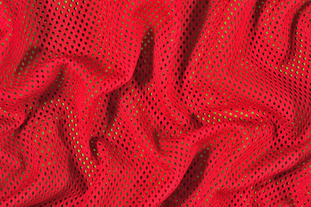 Red crumpled nonwoven fabric on a green backgroundの写真素材