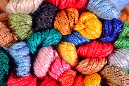 Colorful skeins of floss as background texture close up