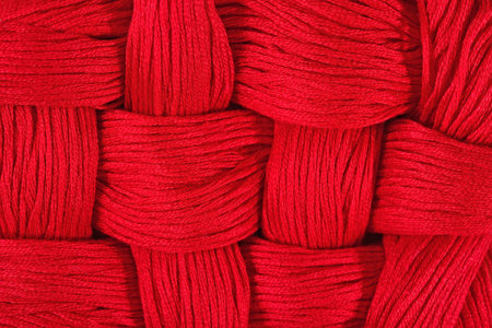 Red embroidery floss as background texture close up