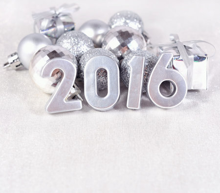 2016 year silver figures on the background of silvery Christmas decorations