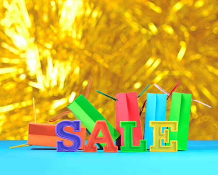 Sale written by colorful letters on the background of shopping bags on a bokeh backgroundの写真素材