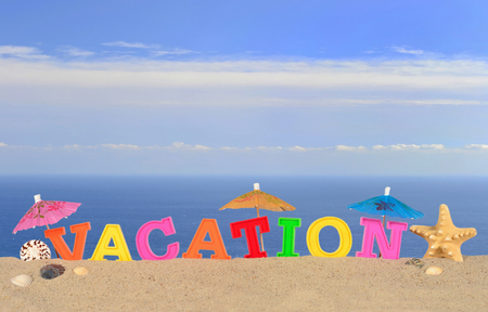 Vacation letters on a beach sand against the background of the seaの写真素材