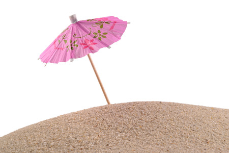 Cocktail umbrella in sand on a white backgroundの写真素材