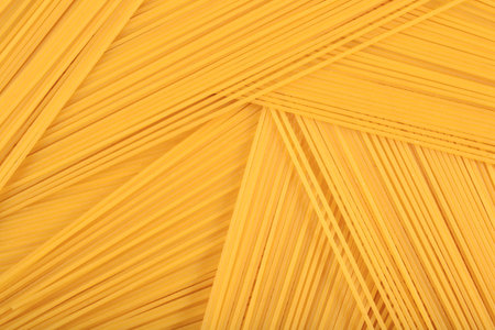 Uncooked Italian pasta spaghetti as background texture