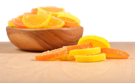 Orange and lemon candy slices in a wooden bowl