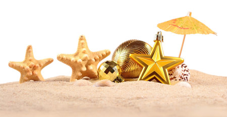 Christmas decorations seashells and starfish on a beach sand on a white backgroundの写真素材