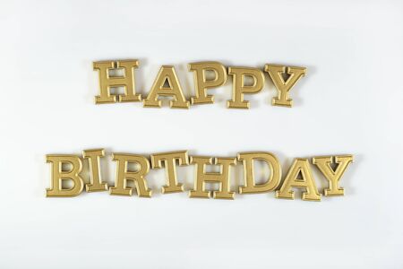 Happy birthday golden text on a white backgroundの写真素材