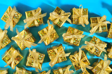 Top view of golden gifts close-up on a blue backgroundの写真素材