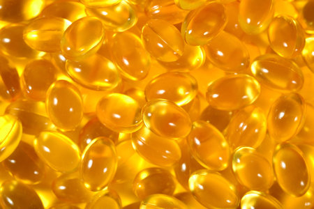 Omega-3 fish fat oil capsules as background texture close up