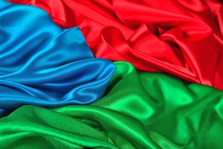 Natural blue, red and green satin fabric as background textureの写真素材