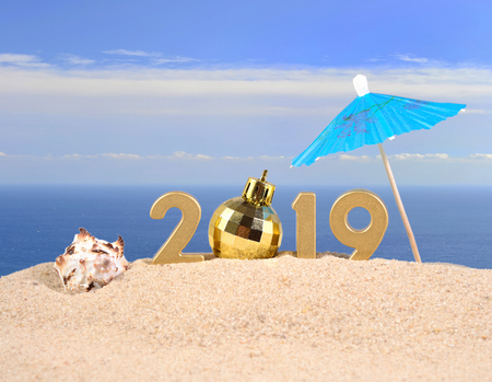 2019 year golden figures with seashell on a beach sandの写真素材