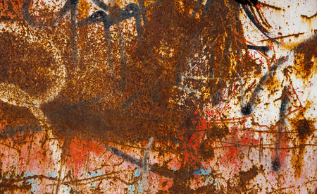Close-up of worn out grunge metal wall with graffiti covered with rustの写真素材