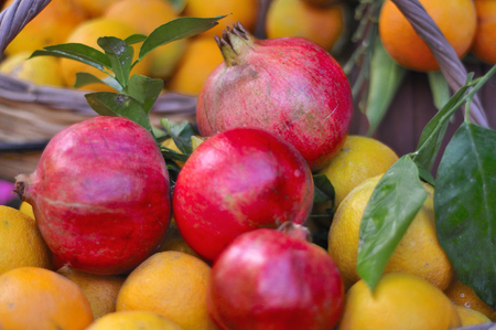 Pomegranates and fresh oranges in a basketの写真素材