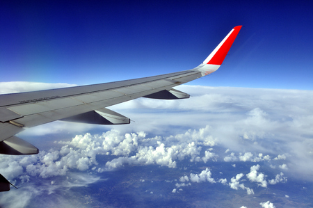 Wing of airplane in flight with view of the earthの写真素材