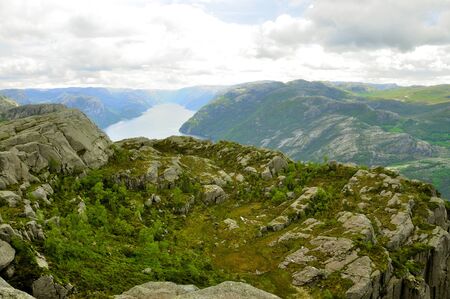 tourists in preikestolen or pulpit in Norway on a day with cloudsの写真素材