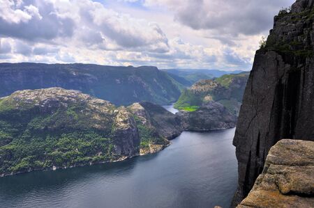 tourists in preikestolen or pulpit in Norway on a day with cloudsの写真素材
