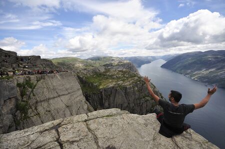 tourists in preikestolen or pulpit in Norway on a day with cloudsの写真素材