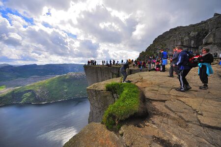 LYSEFJORD-NORWAY, 05JUNE-2017  tourists in preikestolen or pulpit in Norway on a day with cloudsのeditorial素材