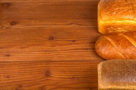 loaves and loaves of brown bread on wooden tableの写真素材