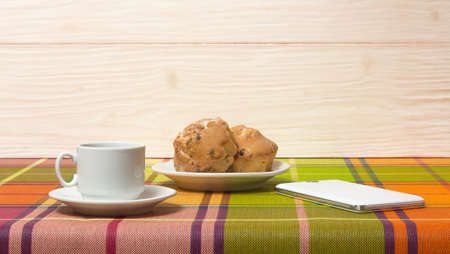 Coffee Cup muffins smartphone on the tableの写真素材
