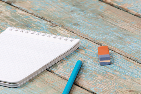 Notebook pencil and eraser on a wooden tableの写真素材