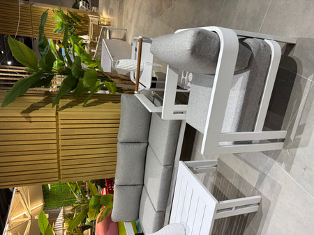 Outdoor seating area with modern white furniture and lush decorative plants.の写真素材