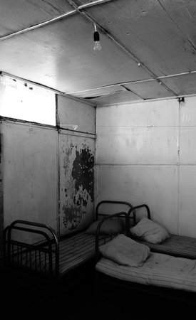 abandoned room with beds and dirty mattresses