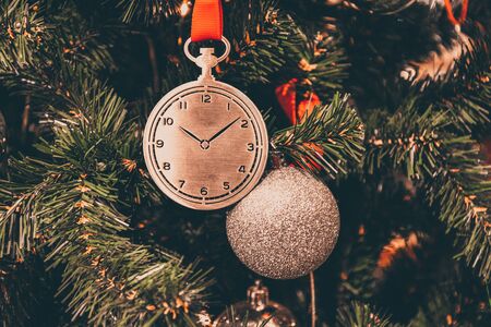toy in the form of clock on Christmas tree branch, clock hangs on branchの写真素材